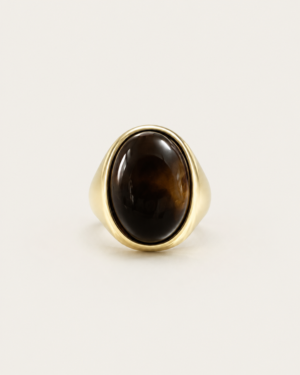 Gold-tone signet ring with a tall dark-brown oval accent, straight-on view of the oval accent.
