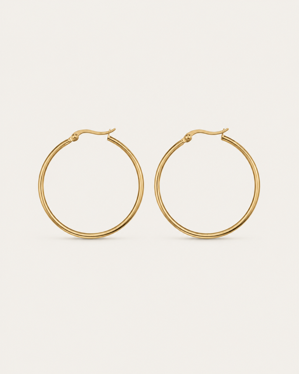 Pair of slim circular gold-tone hoop earrings, shown together.