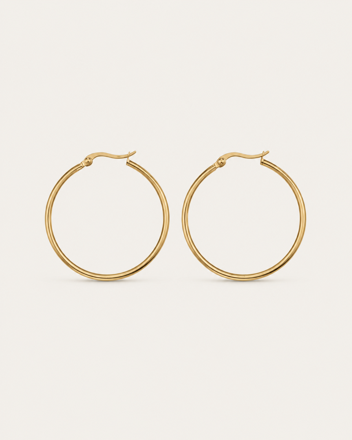 Pair of slim circular gold-tone hoop earrings, shown together.