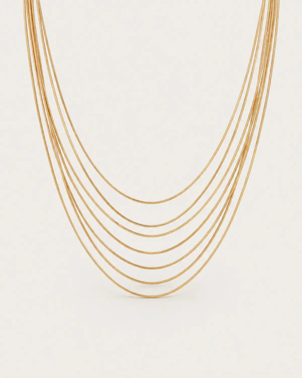 Gold-tone necklace with multiple fine chain strands in graduated lengths, displayed with its joined fastening.