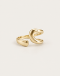 Gold-tone bypass ring with an open loop and tapered end, front view.