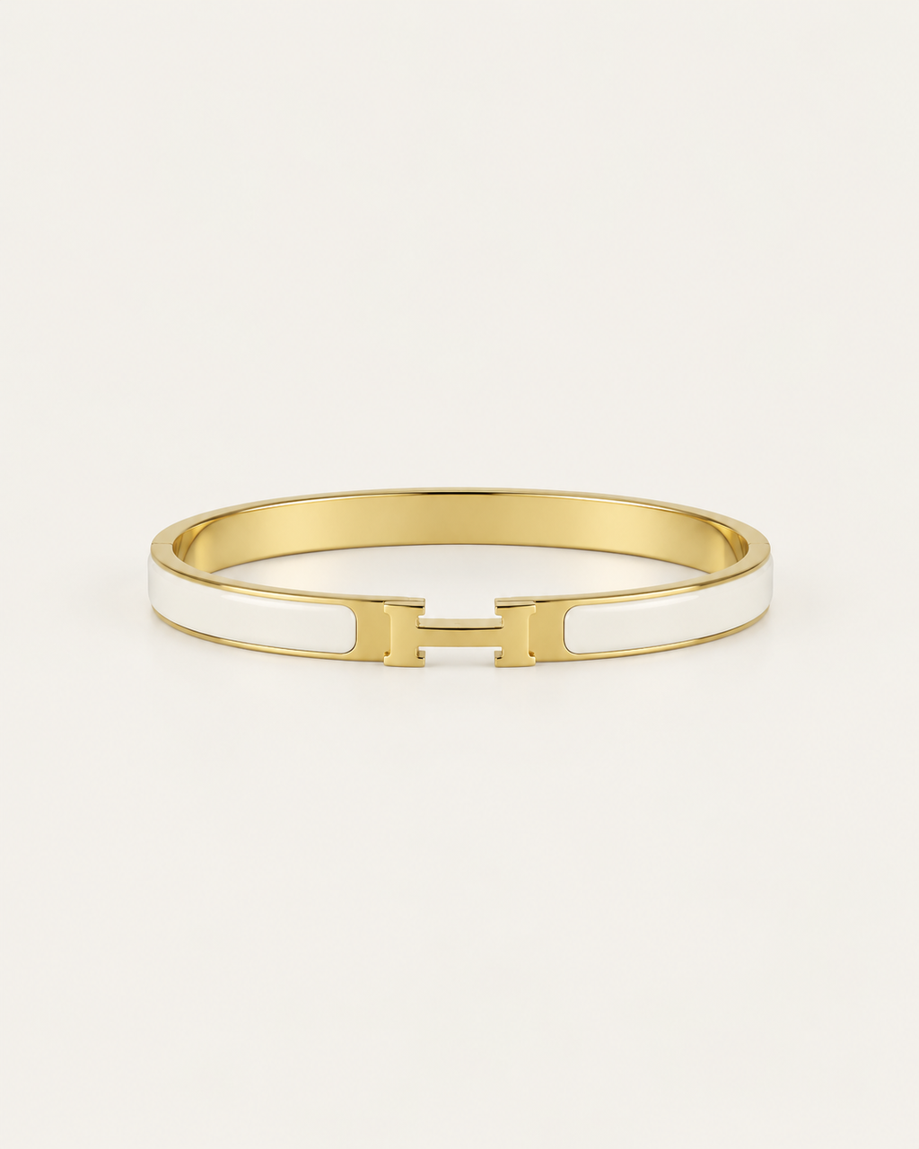 White enamel bangle with gold-tone edges and an H-shaped clasp, front view.