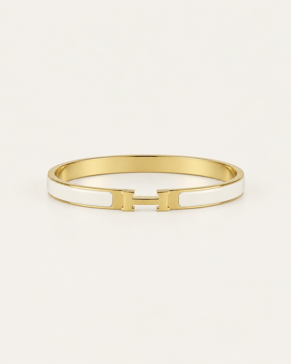 White enamel bangle with gold-tone edges and an H-shaped clasp, front view.