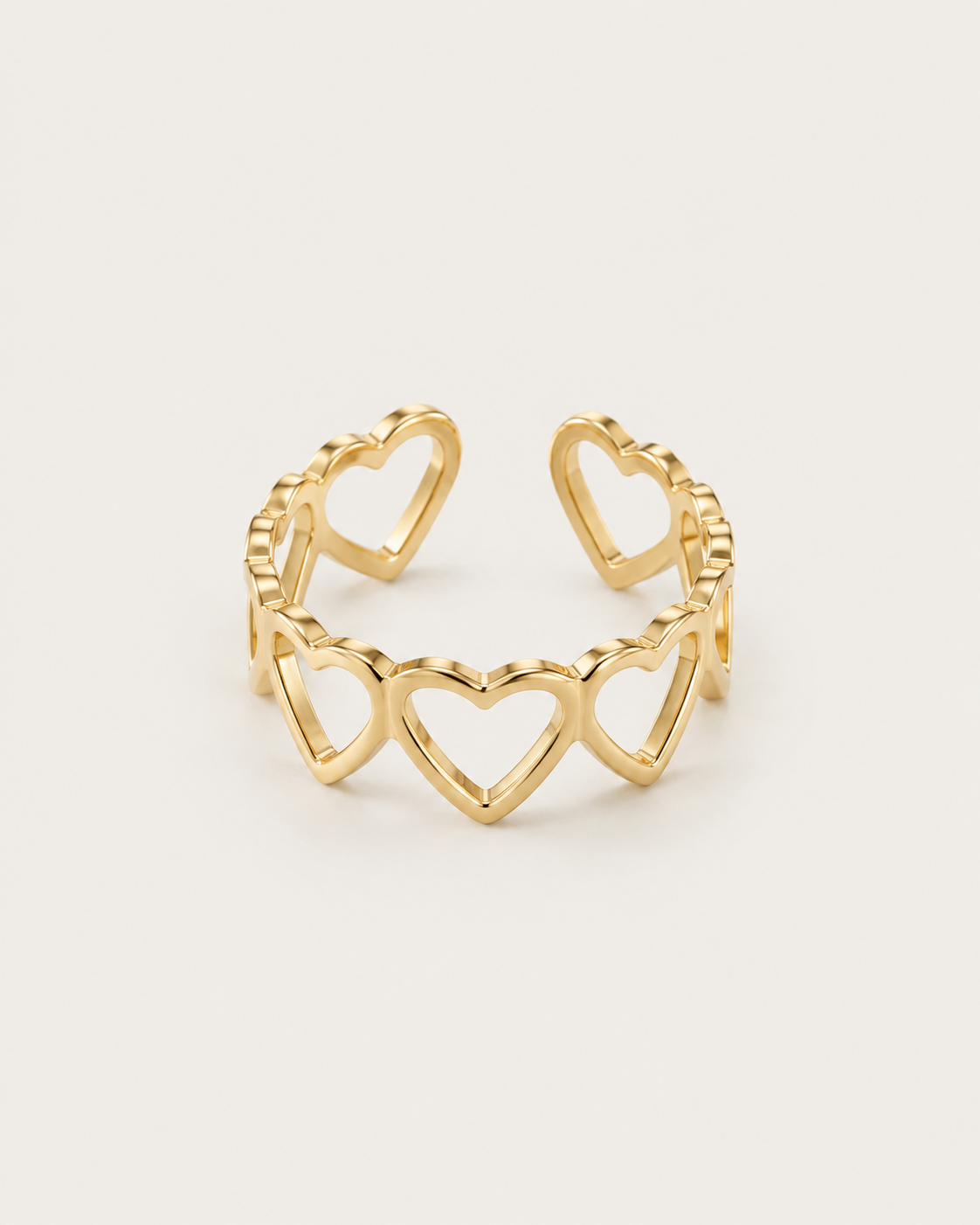 Gold-tone open band ring with linked heart outlines, front view.