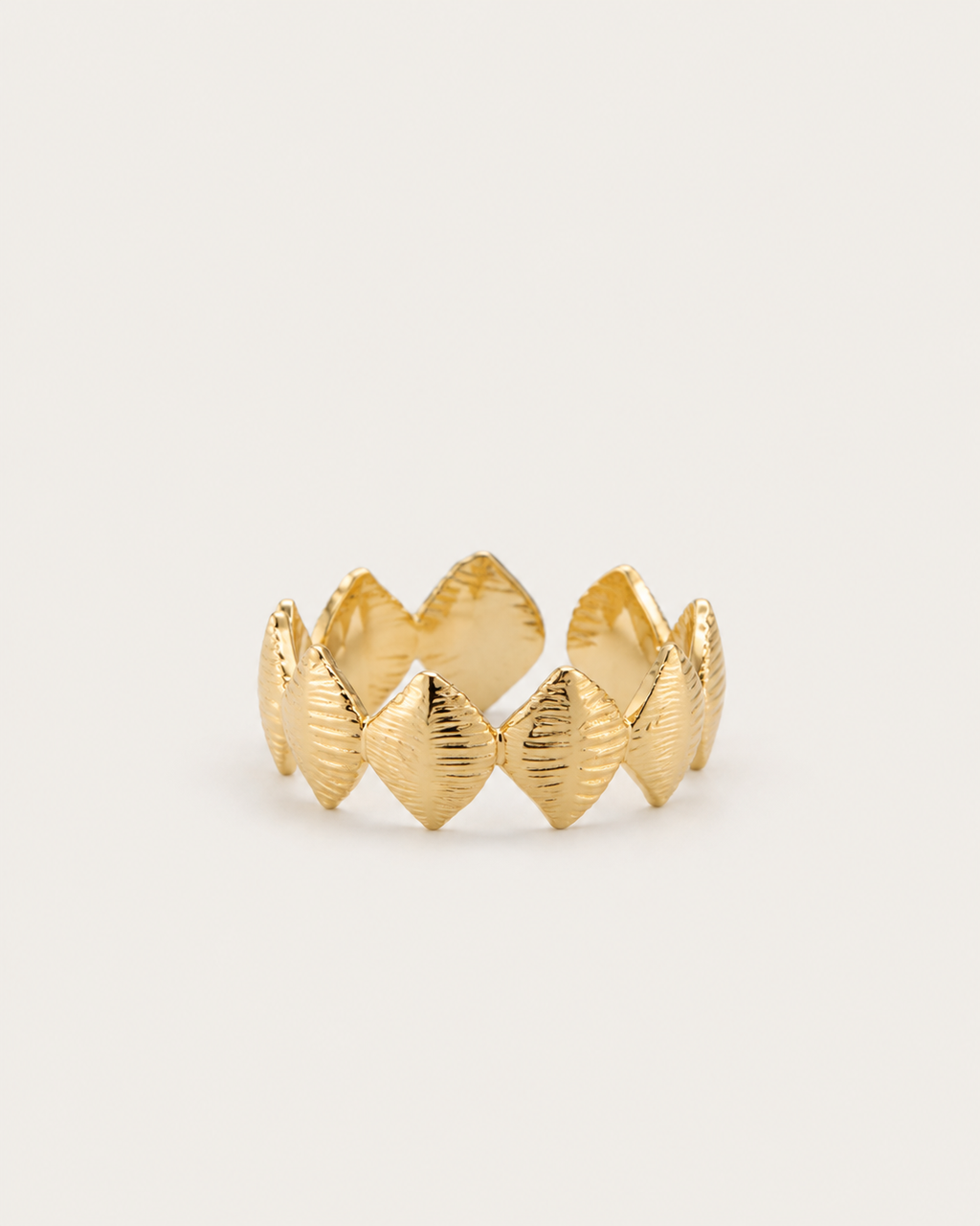 Gold-tone band ring with textured rhombus-shaped motifs, front view.