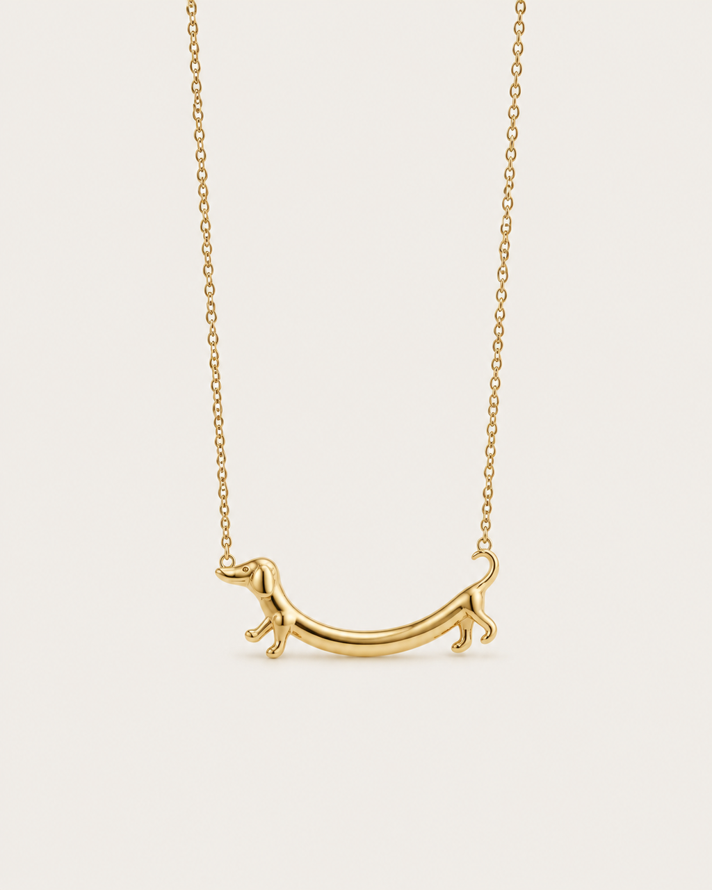 Gold-tone necklace with a dachshund-shaped pendant, front view.