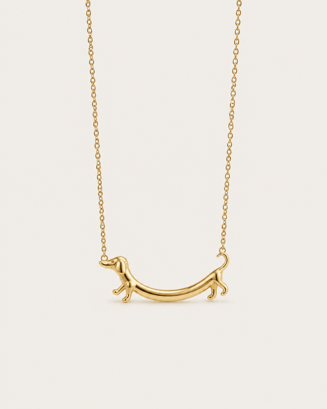 Gold-tone necklace with a dachshund-shaped pendant, front view.