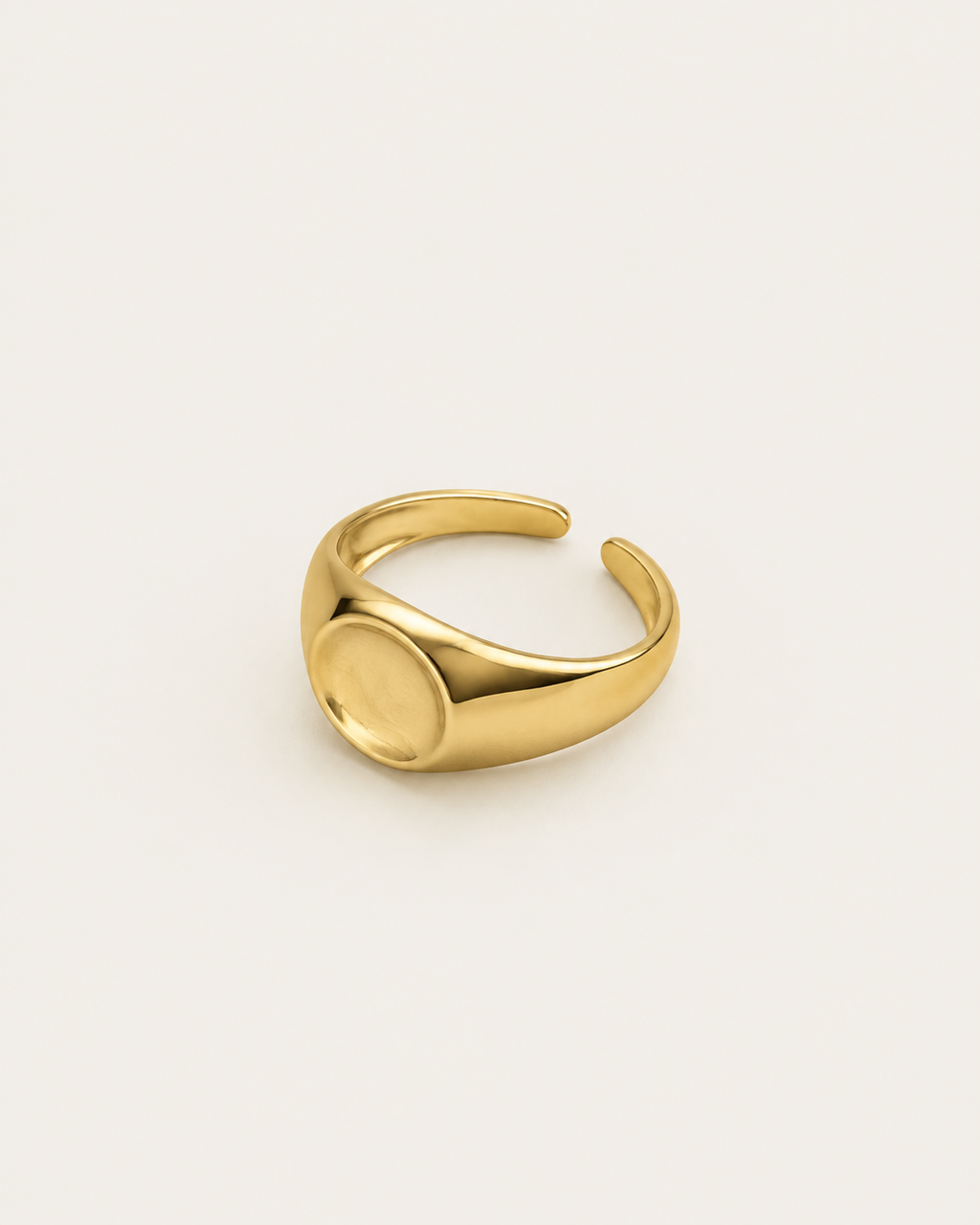 Gold-tone dome ring with a concave circular centre, angled view showing the open back.