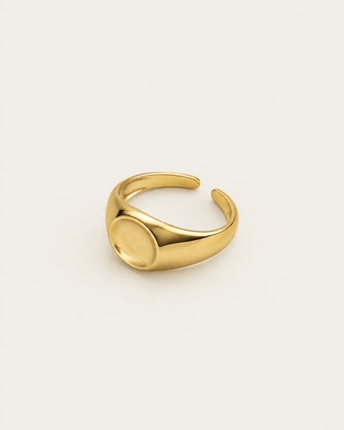Gold-tone dome ring with a concave circular centre, angled view showing the open back.