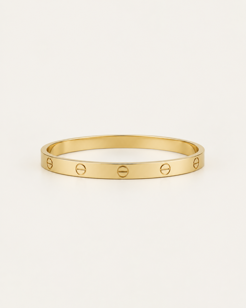 Plain gold-tone bangle with engraved screw motifs, front view.