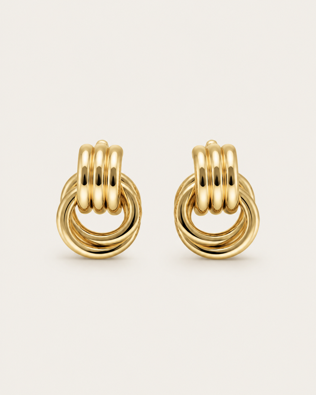 Pair of gold-tone circle drop earrings with small linked upper sections, shown together.