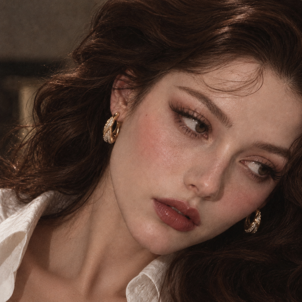 Portrait of a model wearing hoop earrings.