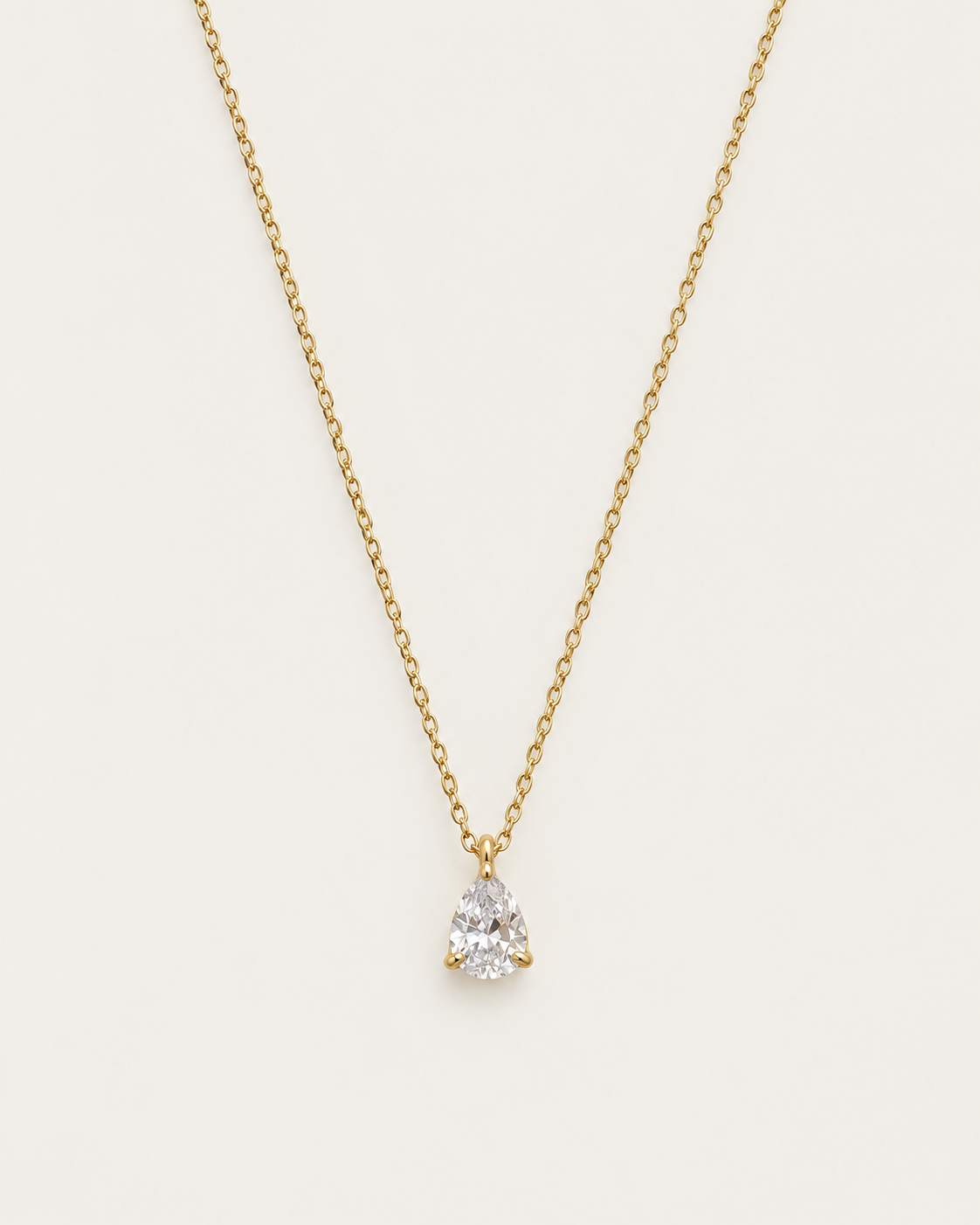 Gold-tone chain necklace with a single pear-shaped clear stone pendant.
