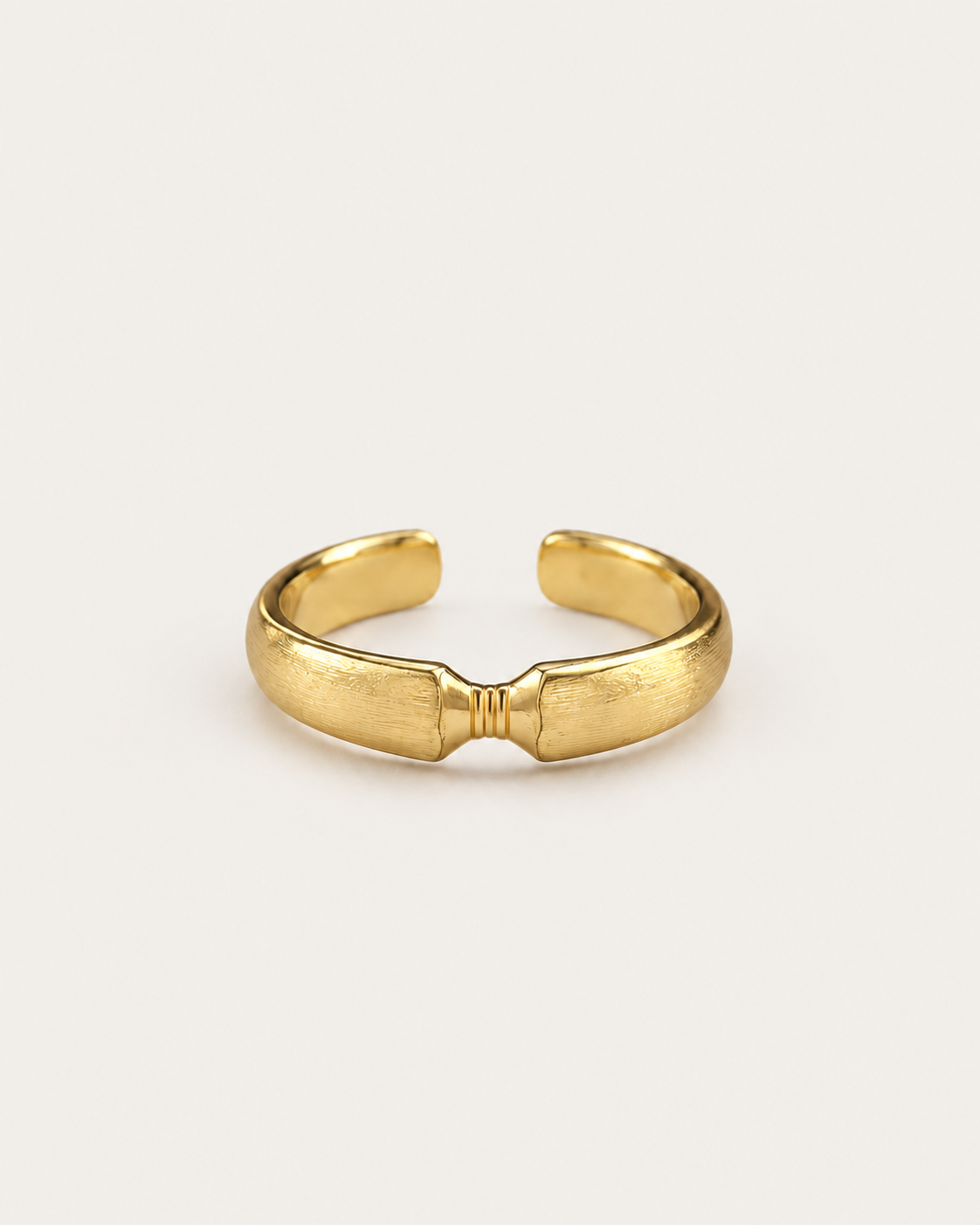 Gold-tone open ribbon-knot ring with a narrow ridged centre.